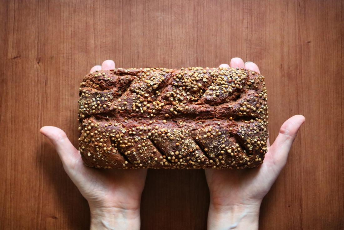 hands holding a loaf of rye bread